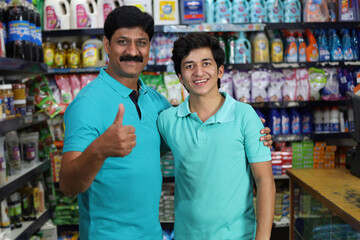 Father and son purchasing in a grocery store. Buying grocery for home in a supermarket. Cheerful father and son holding a product in hand in a mall.