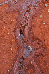 água correndo sobre a terra vermelha 