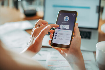 Young woman checking her profile on a bank app while paying bills at home