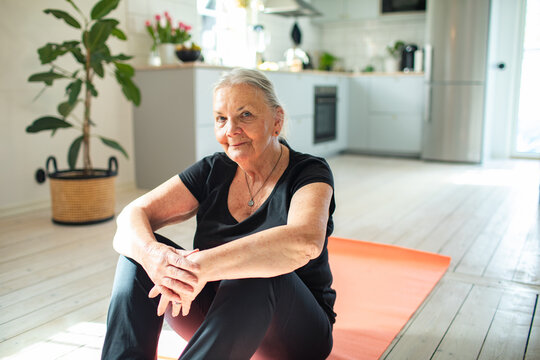 Portrait of a senior woman sitting on the living room floor at home