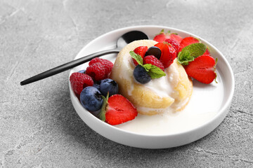 Delicious vanilla fondant served with fresh berries on grey textured table