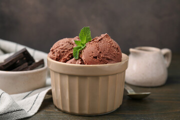 Bowl of tasty chocolate ice cream on wooden table, closeup
