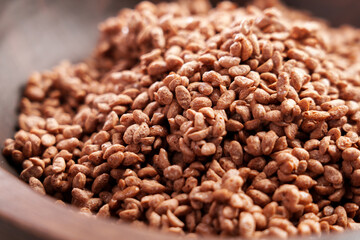 Chocolate cereal rice flakes in brown wooden bowl for morning breakfast