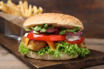 Delicious tofu burger served with french fries on table, closeup