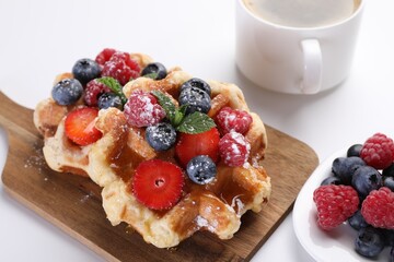 Delicious Belgian waffles with fresh berries on white table, closeup
