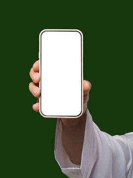 Man's hand holds smartphone with white screen on Islamic or Muslim green. Blank screen with space for copy or promotional content, ideal for app advertising and concepts with focus on Islamic audience
