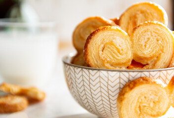 Close up of Puff pastry palmiers in a bowl on a white marble table. Homemade bakery for breakfast.