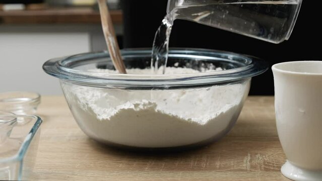 A man mixes salt and flour with his hands to prepare the dough for delicious homemade bread.