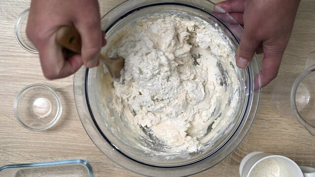 The home cook mixes the ingredients with his hands to prepare the dough for delicious homemade bread.