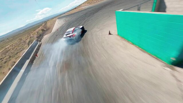 FPV, CALIFORNIA, USA - April 8, 2023: Aerial top view professional driver drifting car on asphalt road track, Automobile drift on abstract asphalt road tire skid mark with lot of smoke of car