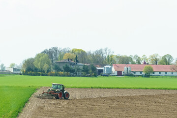A tractor cultivates the land before sowing.