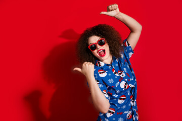 Photo portrait of lovely young lady pointing excited empty space wear trendy blue print x-mas garment isolated on red color background