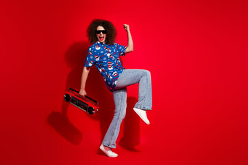 Full length photo of lovely young lady raise fist boombox celebrate wear trendy blue print x-mas garment isolated on red color background