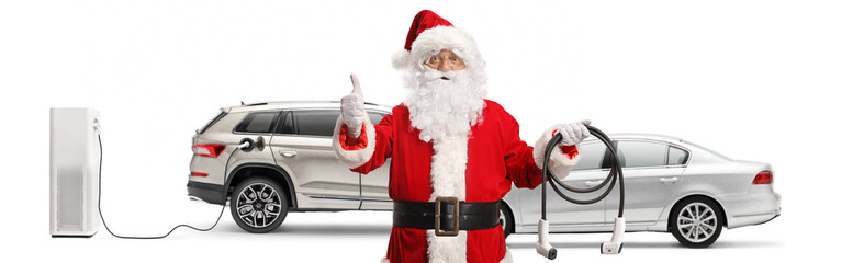 Santa claus with electric vehicles holding charger and gesturing thumbs up