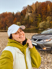 selfie woman near suv car at rocky beach