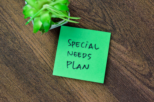 Concept of Special Needs Plan write on sticky notes isolated on Wooden Table.