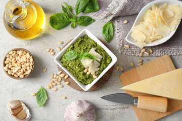 Delicious pesto sauce and ingredients on light table, flat lay