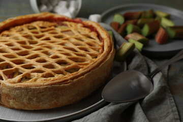 Freshly baked rhubarb pie and cake server on table, closeup