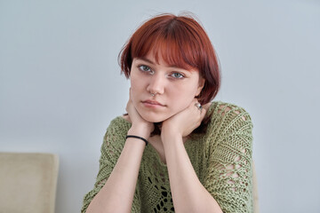 Sad upset teenage female, red-haired girl 19, 20 years old face close-up