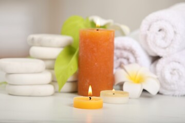 Fototapeta na wymiar Composition with different spa products and burning candles on white table, closeup