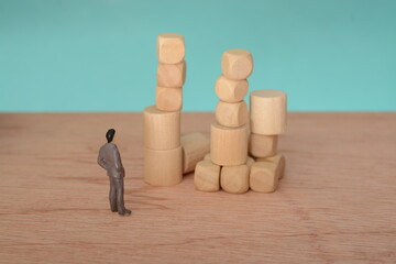 The businessman, deep in thought and surrounded by wooden blocks, pondered the problem and the...