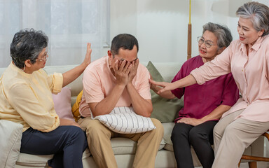 Obraz premium Group mixed genders senior Asian aging female sitting on sofa in cozy nursing home, encourage friend who get diseases, depression. Retirement, Healthcare, Aging Society Concept.