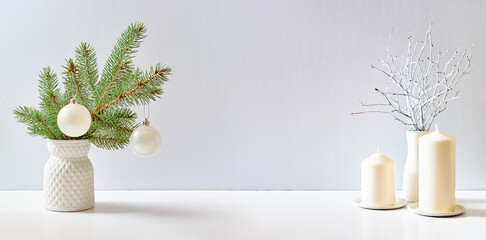 Christmas, New Year home decor. Empty white wall mock up with green fir branches in a vase on a...
