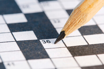 Simple pencil on background of crossword puzzle closeup.