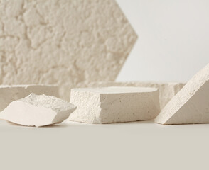 Empty stack of stones platform podium on light beige background. Minimal empty display product presentation scene.