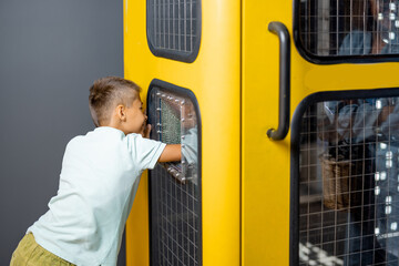 Little boy studying physics and electricity on an interactive model in the science museum. Concept...