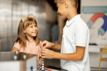 Kids play with magnets while studying physics in the science museum. Concept of children's...