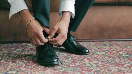 Man tying laces on his black shoes Concept of putting on shoes. Close up