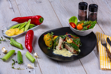 Spinach fish wrap. Spinach wrap served with salad and baked potatoes, fresh vegetables and fruit on the side. Pescetarian food