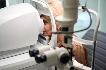 Elegant woman sits in front of a special ophthalmic device