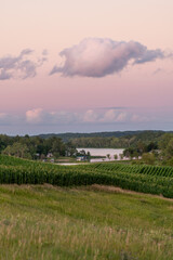 Rolling hills of farmland with a body of water in the evening in rural Minnesota, USA.
