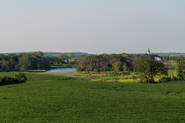 Fototapeta na wymiar The countryside with different crops in the fields, a lake and a white church in rural west central Minnesota, United States. 