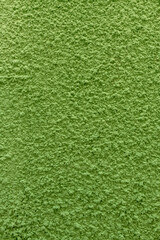 Naklejka premium nieregularna imitacja zielonego trawnika wykonana z betonu i tynku - tło graficzne