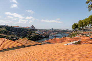 słynny most w Porto widziany tuż nad pomarańczowymi dachami kamienic  - obrazy, fototapety, plakaty