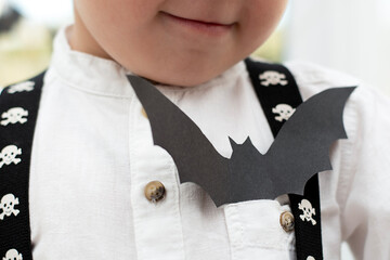 Halloween concept. Autumn holiday. Little boy, no face. In the pocket of a white shirt sits a bat...