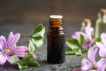 A dark bottle of mallow essential oil on a table