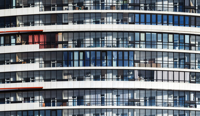 White round house facade with glazed balconies. Abstract modern architecture