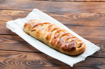 apple braided pie on a wooden background. the concept of homemade fruit pastries