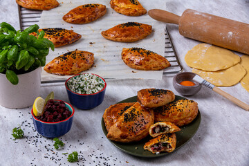 Beetroot and cheese vegan pastry. Presentation decorated with rolling pin, flour, dough and egg. Ramadan food, white patina background, food photography
