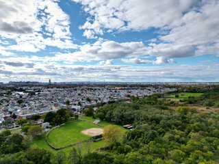 aerial view of marine park, brooklyn (baseball diamond field, neighborhood houses, distant verazzano bridge) drone photo with clouds in the sky, trees, public park in new york city