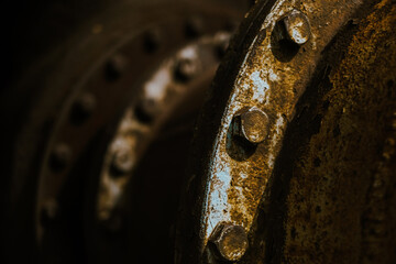 Detail of old and rusty screws in a huge pipe of an old factory