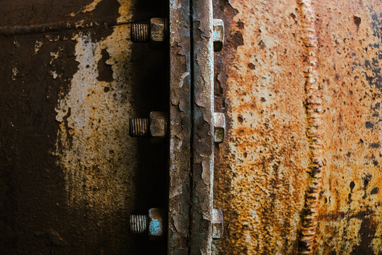 Detail of old and rusty screws in a huge pipe