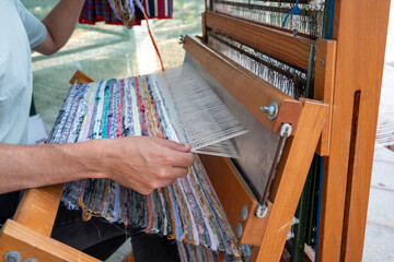 Hands weaving on a silk loom in the Canary Islands