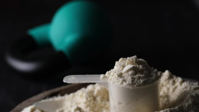 Focusing on a measuring spoon with whey protein powder, the kettlebell enthusiast enjoys sport food and supplements.