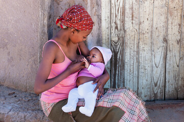 young african mother in the village breast feeding her baby
