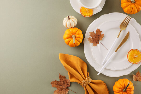 Generate a Thanksgiving table to be remembered. Top view flat lay of plates, cutlery, cup, pumpkins, seasonal attributes, napkin, autumn leaves on pastel green background with advert area